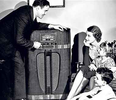 Family sitting around the radio listening to old time radio.